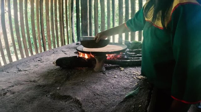 Traditional Cooking Over Fire in Ecuador Amazon House with Hot Pan, Smoke, Wooden Walls and Rural Food Preparation Cultural Scene