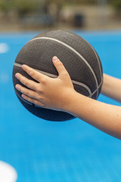 Child holding basketball during outdoor skills practice
