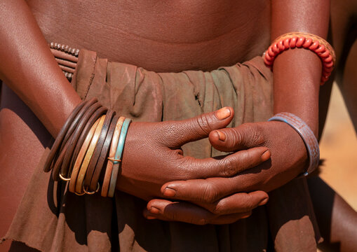 Close-up of two clasped hands adorned with colorful beaded and rubber bracelets, Cunene Province, Oncocua, Angola