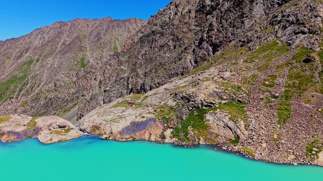 Ala Kul lake waterfall with drone flying overhead