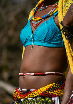 Close-up of a Mudimba tribe woman's torso adorned with beaded necklaces and a waist belt over traditional clothing, Cunene Province, Cahama, Angola