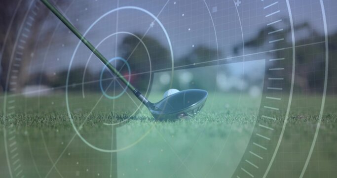 Aligning metal golf driver head behind golf ball resting on tee grass, with translucent HUD overlay