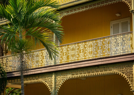Multiple tiers of ornate ironwork balconies at the Palacio de Ferro seen through palm fronds, Luanda Province, Luanda, Angola