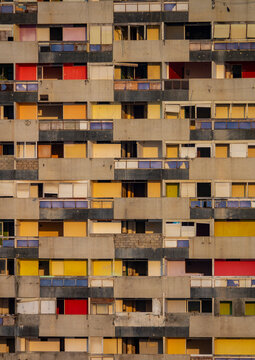Rows of weathered concrete balconies with multicolored doors cover the facade of an abandoned apartment building, Luanda Province, Luanda, Angola