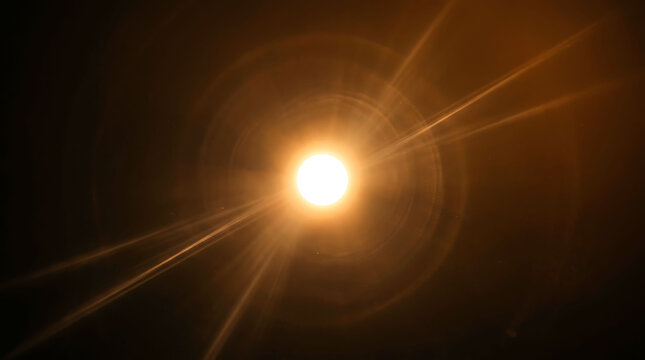 Bright glowing sun or star with dramatic lens flare effects in dark space