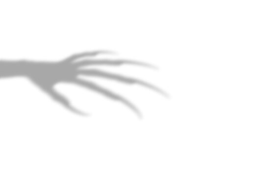 A dark scary shadow of a monster hand with long sharp claws reaching out from the side presented as an isolated on transparent background image