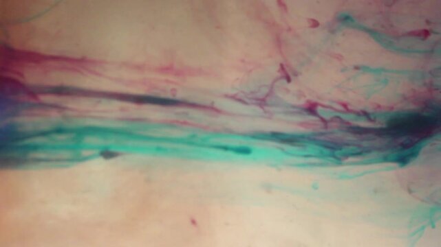 A blend of soft blue, pink, green, and yellow hues flowing like ink or liquid paint across the water's surface. The gentle movement and organic textures create an artistic, soothing atmosphere.