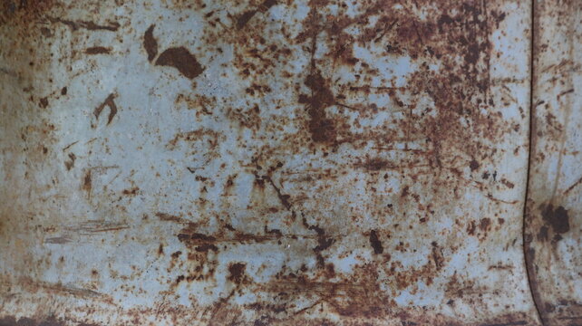 Rusty metal texture with scratches. A close-up of an old iron sheet featuring extensive orange-brown corrosion and scuff marks. A suitable grunge background for designs and collages.
