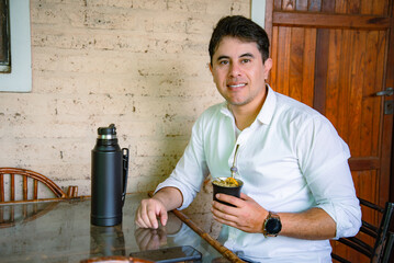 Hombre tomando mate sentado a la mesa en casa © Daniel