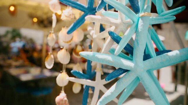 Painted blue starfish ornaments dangling above a market table in Amalfi