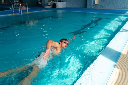 Athlete practicing freestyle stroke in blue water