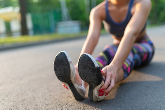 Close up of a fit woman stretching her legs on the ground