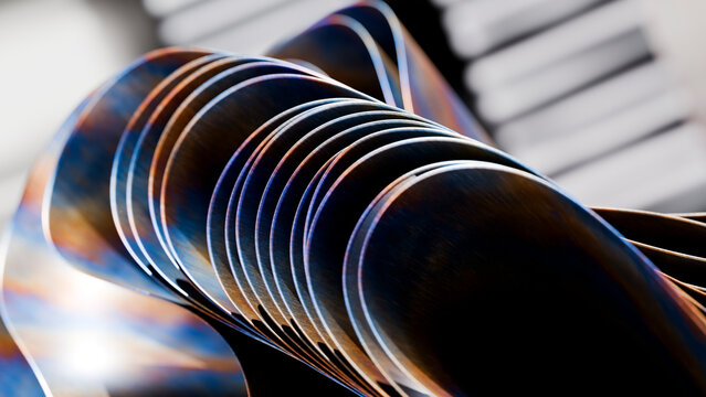 Row of metal spoons showing reflective curved surfaces