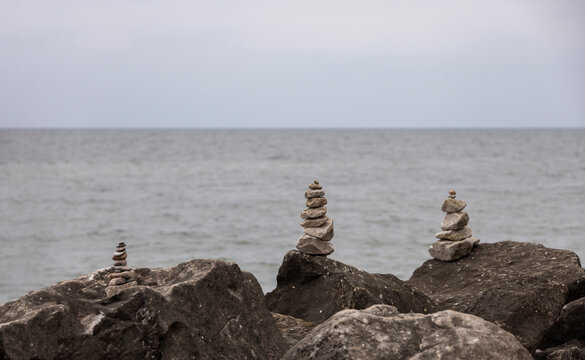 Stone inukshuks stand on Pelee Island rocks by Lake Erie in Ontario, Canada.
