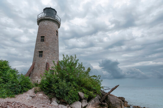 Historic lighthouse on Pelee Island, Ontario, against a dramatic sky over Lake Erie.