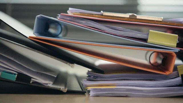 Stack of Business Documents and File Folders on Office Desk