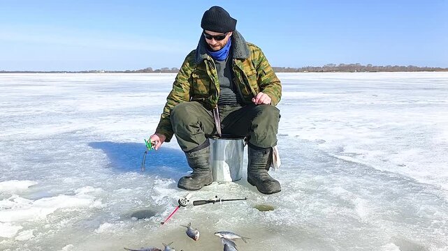 A man fishes on the ice of a frozen lake.