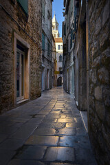 Fototapeta premium Narrow old stone street in Split Croatia with cathedral bell tower view