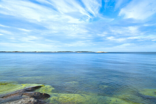 Calm Sea at Rocky Skerry Coast Under Dynamic Cloudy Sky, in sweden.