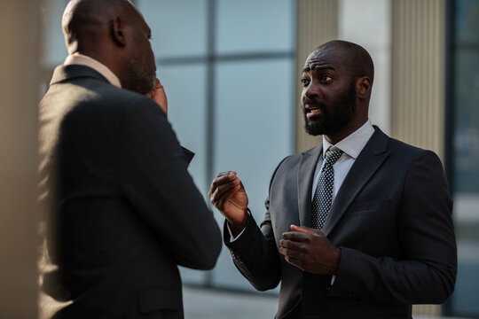 Two businessmen discussing strategy outside office