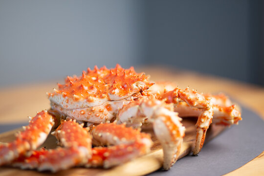 Cooked king crab legs arranged on a plate on a table, gourmet seafood presentation, fine dining, culinary art.