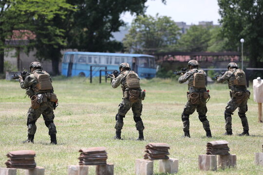 Armed special forces soldiers in camouflage tactical gear during a tactical combat exercise or combat operation
