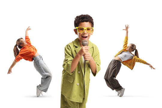 Kid singing into a microphone and two girls dancing