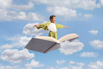 Obraz premium Boy flying on an open book with arms spread
