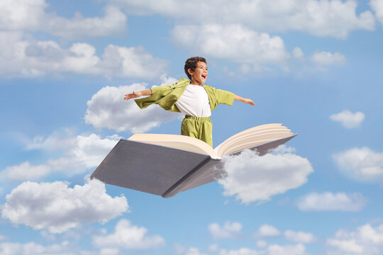 Boy flying on an open book with arms spread