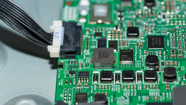 Wire harness connector plugged into green circuit board with SMD components