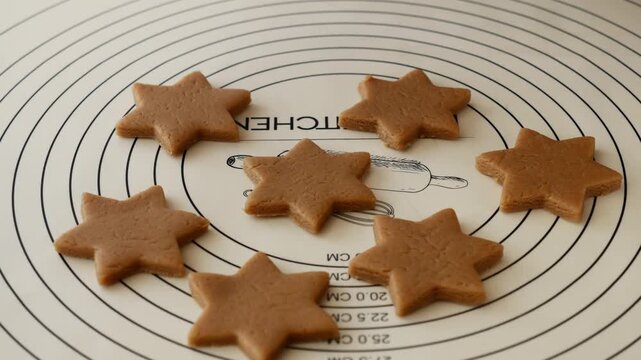 Close-up of woman holding star shaped gingerbread cookie dough for homemade Christmas baking.
