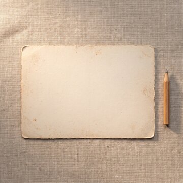 Blank aged paper card with wooden pencil on linen cloth