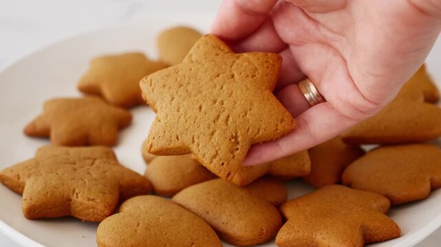 Close-up of woman holding homemade gingerbread star cookie for Christmas holiday.