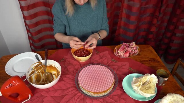 Woman peel pomegranate. Hands with Fruits on table. Cooking food at home.