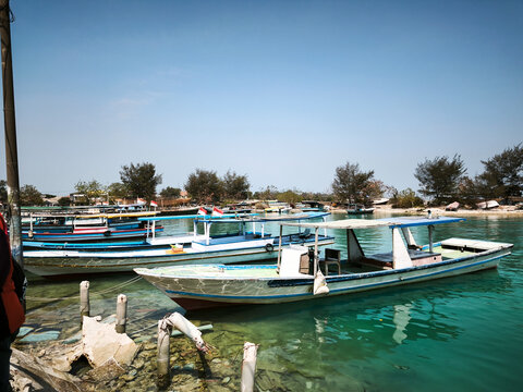 Thousand Islands, Indonesia  06 September 2026 Row of traditional wooden boats moored along sandy tropical island coast.