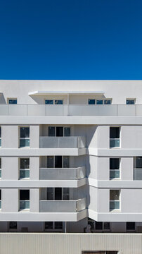 White residential facade with balconies and glass balustrades