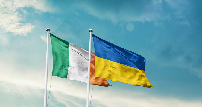 Ireland Ukraine friendship flags are waving in the sky. Two country flag for agreement or deal. Ireland Ukraine national flag for commitment.