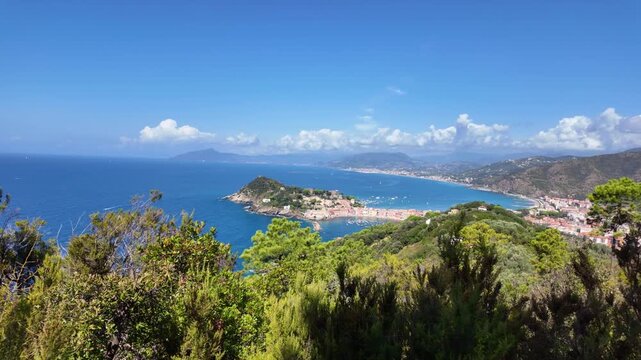 Coastal town and bay viewed from hillside with green shrubs. Sestri Levante, Italy