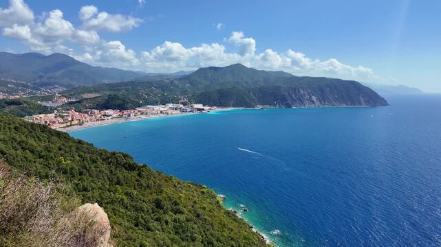 Seaside town and curved bay from rocky cliff viewpoint. Riva Trigoso, Italy