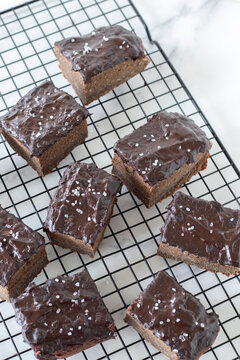Chocolate cake slices with homemade vegan icing on a cooling wire rack. Top view.