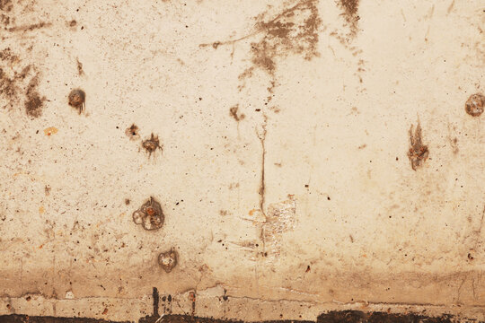 Grungy weathered concrete wall texture with cracks and bullet holes