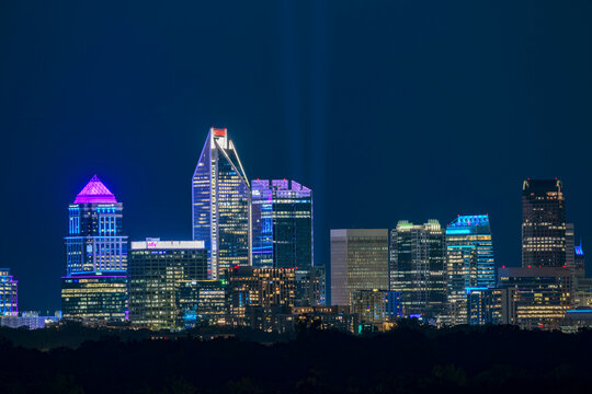 Charlotte, NC uptown skyline featuring purple and blue building led colors and two blue beams in remembrance of the 25th anniversary of 9/11