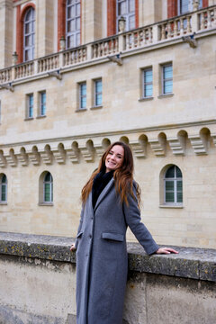 Smiling woman in gray coat beside Saint-Germain-en-Laye Chateau