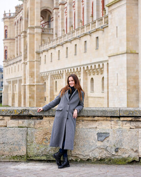 Woman in gray coat posing by Saint-Germain-en-Laye Chateau