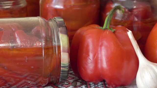 Jars of preserved bell pepper and fresh vegetables close up, Autumn food preservation and home canning process