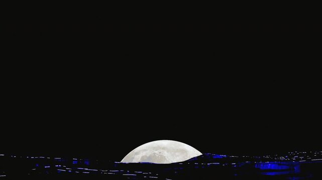 Full moon rising over ocean surface during stormy waves with reflection on water
