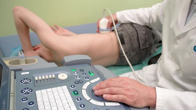 07.07.25. Moscow. Russia. Ultrasound examination of the abdominal cavity. The patient lies on his side, the doctor uses an ultrasound sensor and monitors the image on the device screen. Without faces.