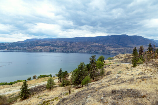 Expansive lake vista with rolling hills and distant mountains under a cloudy sky, Knox mountain park, Kelowna, BC V1Y 9X3, Canada