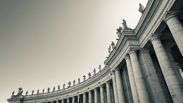 Low angle view of Gian Lorenzo Bernini's 17th century colonnade in St Peter's Square, Vatican City, with marble columns and statues of saints Architectural travel detail with copy space