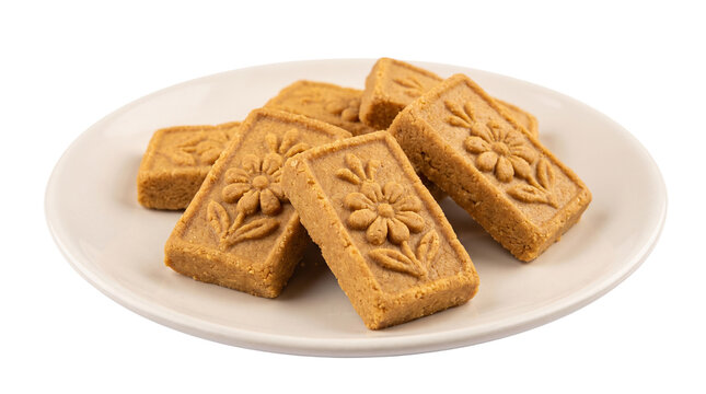 Authentic Brown Nolen Gur Sandesh with embossed floral patterns, on the plate isolated on crisp